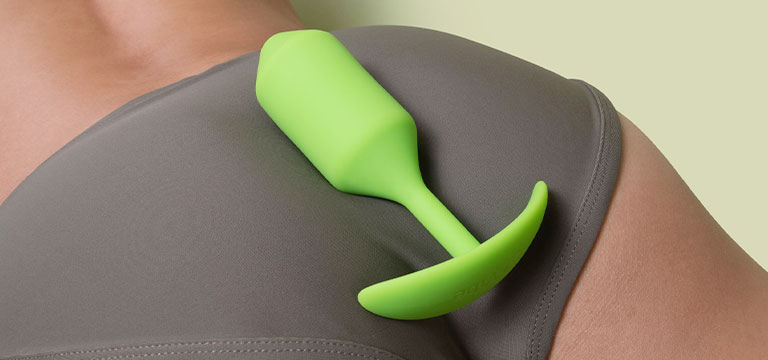 A bVibe butt plug sits atop the swell of a person's buttocks.