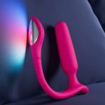 The Lovense Lush Anal sits against a pillow in dim room. It's a great beginner butt plug for people of all genders.