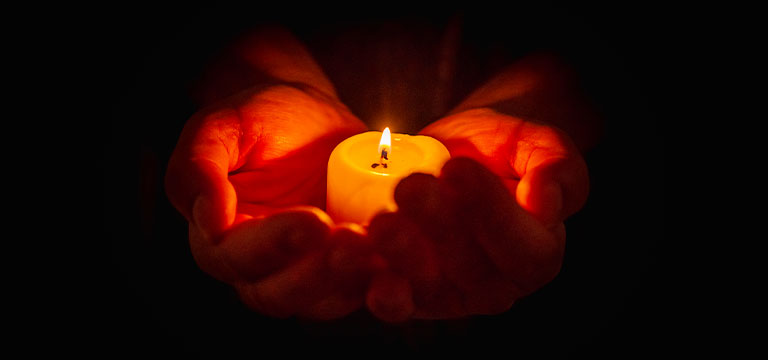 A lit candle sits in a person's cupped hands. Wax play involves dripping hot wax onto your lover's body. Or sometimes your own.